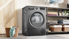 Gray dryer in a laundry room with shelves and baskets. Thumbnail