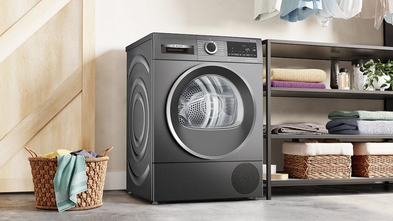 Gray dryer in a laundry room with shelves and baskets.